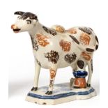 A Pratt Type Pottery Cow Creamer, circa 1810, the standing beast with brown markings, a seated