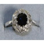 A Sapphire and Diamond Cluster Ring, an oval cut sapphire within a border of eight-cut diamonds in