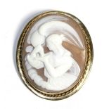 A Carved Shell Cameo Brooch, depicting Hebe and Zeus, in an oval rope frame, measures 5.7cm by 5cm