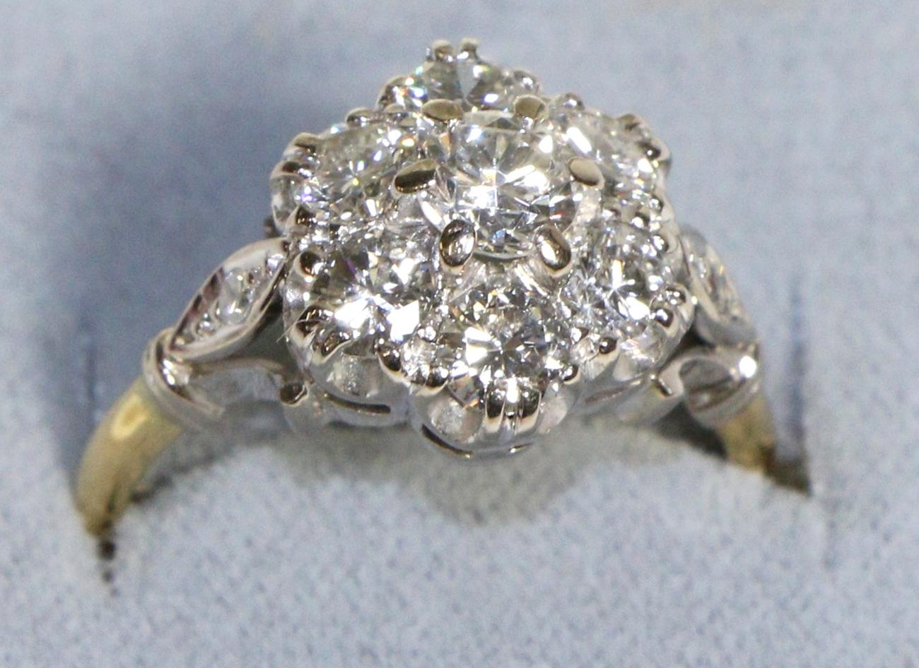 A Diamond Cluster Ring, seven round brilliant cut diamonds in claw settings, to forked diamond set