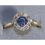 A Sapphire and Diamond Cluster Ring, a round cut sapphire within a border of eight-cut diamonds,