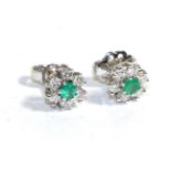 A Pair of 18 Carat White Gold Emerald and Diamond Cluster Earrings, a round cut emerald within a