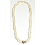 A Double Strand Cultured Pearl Necklace, uniform cultured pearls knotted to a 9 carat gold pearl set