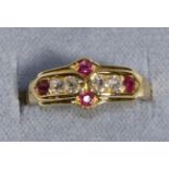 An 18 Carat Gold Diamond and Ruby Ring, four old cut diamonds spaced by round cut rubies in a carved