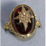 A 9 Carat Gold Carbuncle Garnet and Diamond Ring, an oval garnet inset with a diamond set star