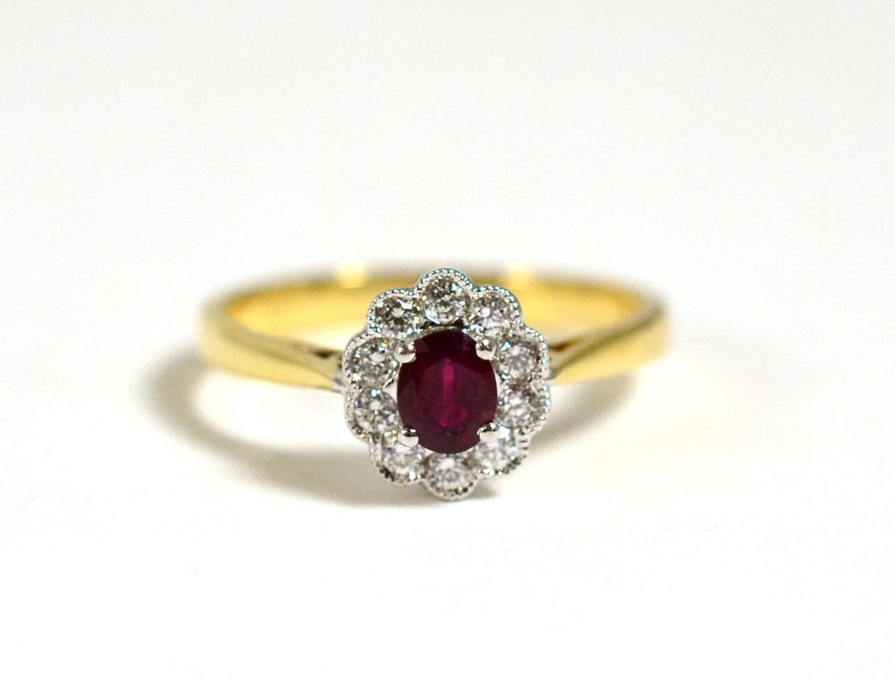 A Ruby and Diamond Cluster Ring, a round cut ruby in a claw setting, within a border of round