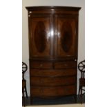 A George III Mahogany Bowfront Linen Press, with two cupboard doors inlaid with oval panels