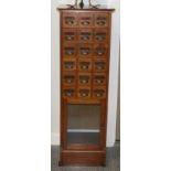 A Late Victorian Mahogany Index Cabinet, with eighteen small drawers above a glazed door, raised