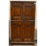 An Arts & Crafts Style Carved Oak Cupboard, with four linen-fold panel doors with stylised hinges