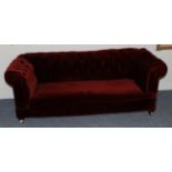 A Victorian Chesterfield Drop-End Sofa, 3rd quarter 19th century, covered in buttoned red velvet