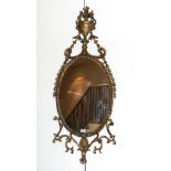 A George III Gilt and Gesso Oval Pier Glass, late 18th century, the ropetwist frame surmounted by an