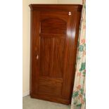 An Early 20th Century Mahogany Corner Wardrobe, with arched cupboard door and three moulded panels