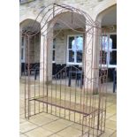 A Patinated Metal Garden Gazebo Arch/Seat, with scrollwork and twist decoration and slatted seat,