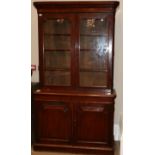 A Victorian Glazed Mahogany Bookcase, circa 1870, the bold pediment above glazed doors enclosing