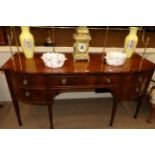 A George III Mahogany and Boxwood Strung Bowfront Sideboard, early 19th century, with a brass rail