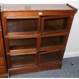 An Early 20th Century Oak Three Section Bookcase, with six glazed doors, raised on a plinth base,