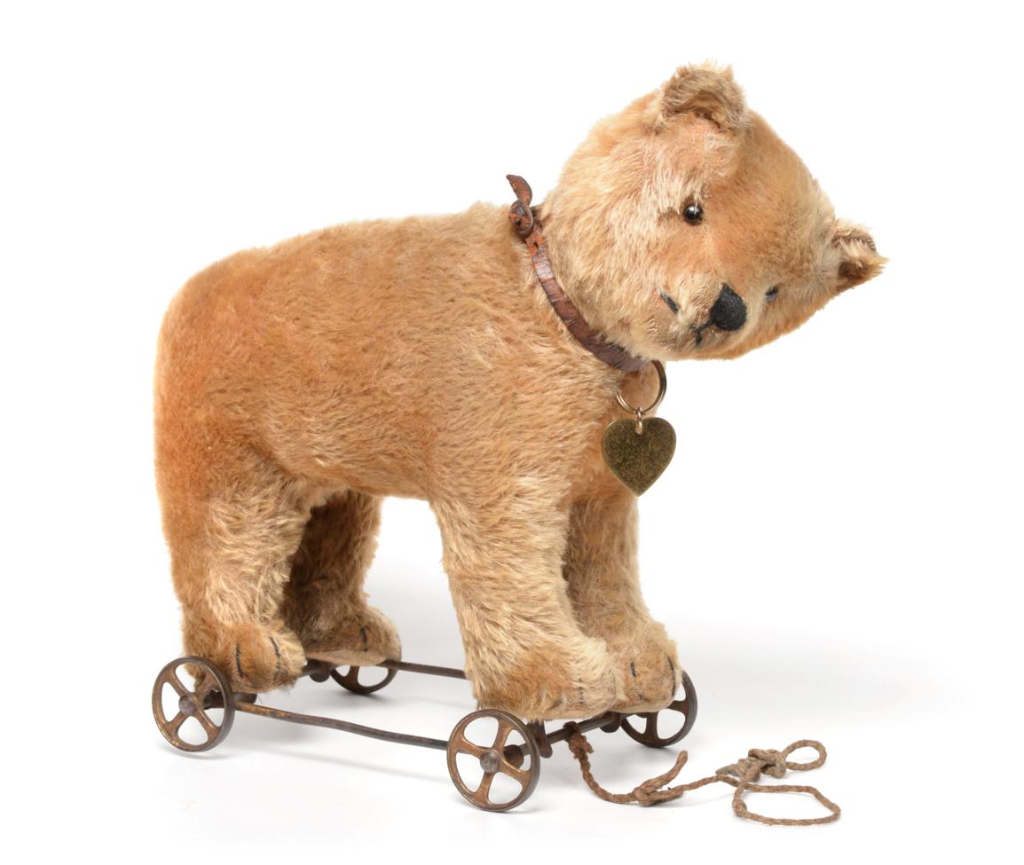 Circa 1930 Schuco Yellow Plush Bear on Wheels, with jointed head, stitched nose and claws, boot