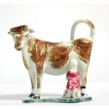 A Pearlware cow creamer, circa 1820, the standing beast with brown sponged markings, a milkmaid