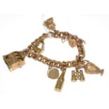 A chased curb link charm bracelet, stamped '9CT', with a padlock clasp and seven charms, including a