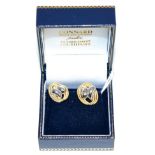 A pair of 18 carat two colour gold earrings white gold scrolls within a yellow gold rope frame,