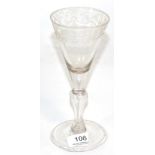 A light baluster wine glass, circa 1750, the funnel bowl engraved with a band of scrolling