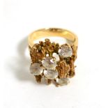A 1970s cubic zirconia cluster ring, round cut cubic zirconia to a textured bar top, finger size
