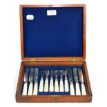 A silver bladed and mother of pearl handled set of fruit knives and forks in an oak case