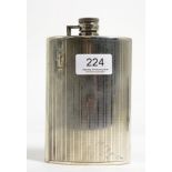 A white metal hip flask, stamped 'Silver', of curved form with engine turned decoration, 15cm