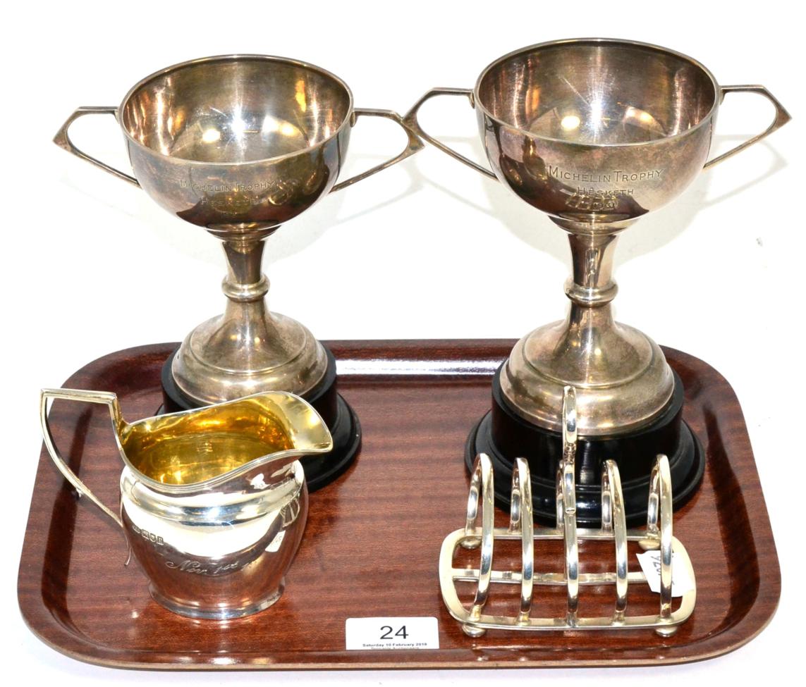 A silver toast rack, by Hukin and Heath, Birmingham, 1928; with two silver twin handled trophy