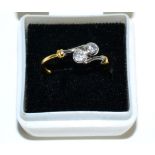 An 18 carat gold diamond cross over ring, two round brilliant cut diamonds in rubbed over
