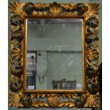 A gilt mirror within a beaded border with pierced acanthus scrolled and shell decorated frame,