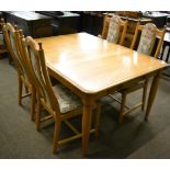 An Ercol oak five piece dining suite comprising a table and a set of four high back chairs