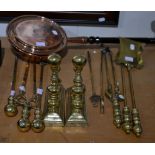 A pair of brass andirons, two sets of three fire tools and an additional two fire pokers and a