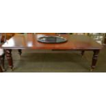 A Victorian mahogany wind out dining table with two additional leaves and winder