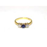 A sapphire and diamond three stone ring, a round cut sapphire spaced by round brilliant cut