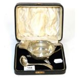 A silver sauceboat and ladle, in fitted case