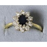 An 18 carat gold sapphire and diamond cluster ring, an oval cut sapphire within a border of round