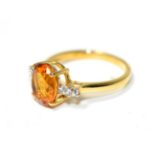 A 9 carat gold citrine and white zircon ring, an oval cut citrine in a claw setting, to zircon set