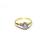 A solitaire diamond ring, a round brilliant cut diamond in a claw setting, to tapered scroll