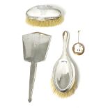 A carved shell cameo brooch; an Art Deco silver hand mirror; and two silver dressing table brushes