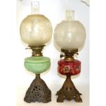 Two Victorian oil lamps, one with a painted cranberry reservoir the other opaque green glass (2)
