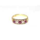 A ruby and diamond ring, three round cut rubies, spaced by old cut diamonds, to a carved setting,