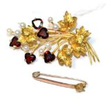 A garnet and cultured pearl spray brooch, heart cut garents in claw settings and cultured pearls