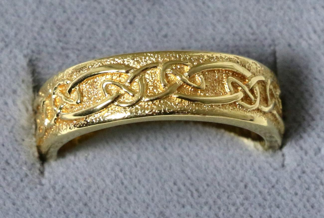 An 18 carat gold Celtic motif band ring, finger size M1/27.4 grams