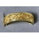 An 18 carat gold Celtic motif band ring, finger size M1/27.4 grams