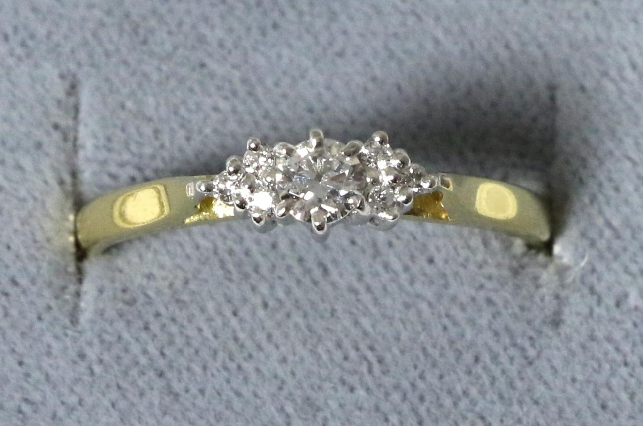 An 18 carat gold diamond ring, a round brilliant cut diamond to diamond set shoulders, total