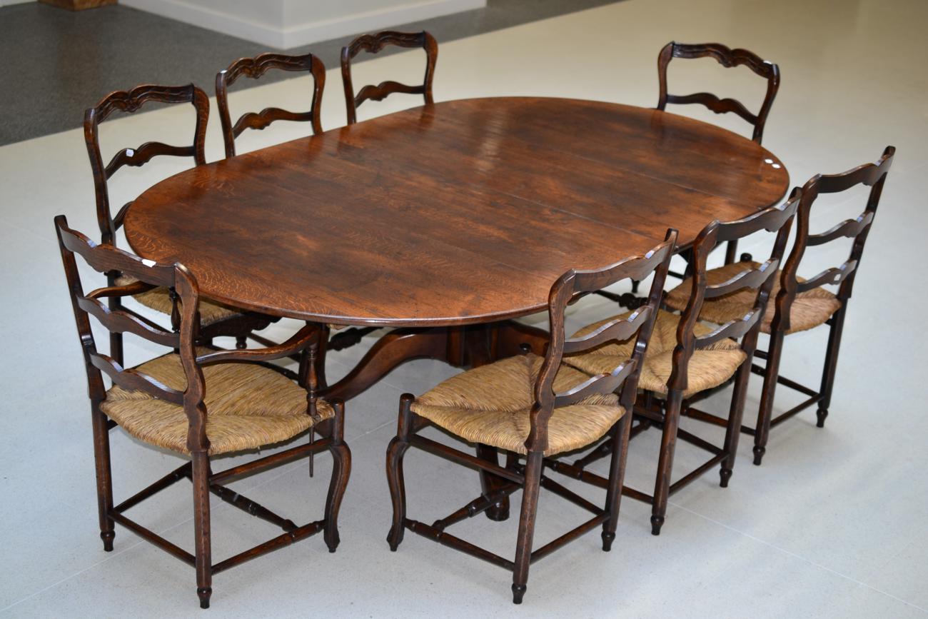 A Reproduction Oak Extending Dining Table, of circular form with two additional leaves, raised on