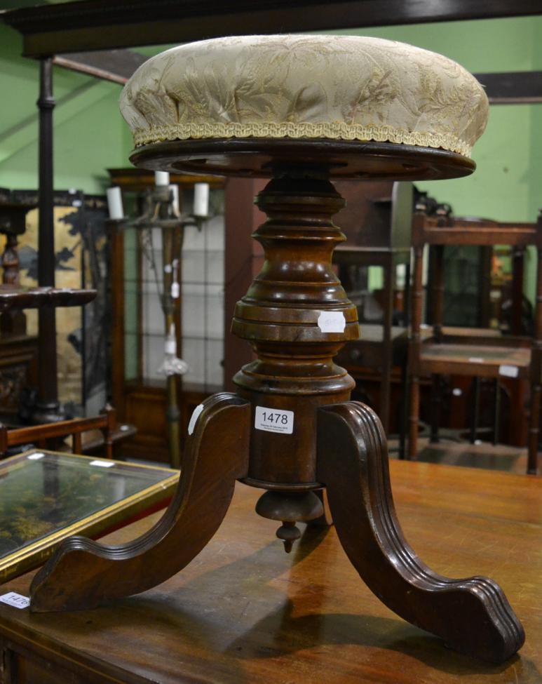 A late Victorian walnut revolving piano stool, circa 1880, the circular overstuffed seat rotating on