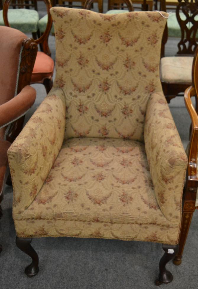 A Victorian armchair, upholstered in beige and pink floral fabric with rounded arms and