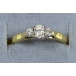 An 18 carat gold diamond three stone ring, an oval cut diamond between two round brilliant cut